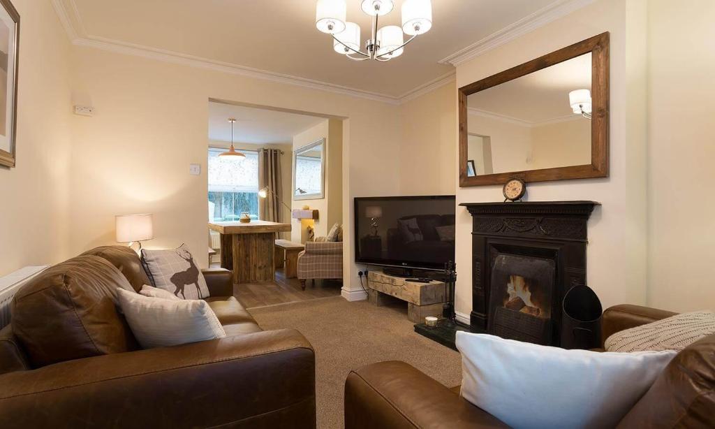 a living room with a couch and a fireplace at Noble Cottage in Keswick