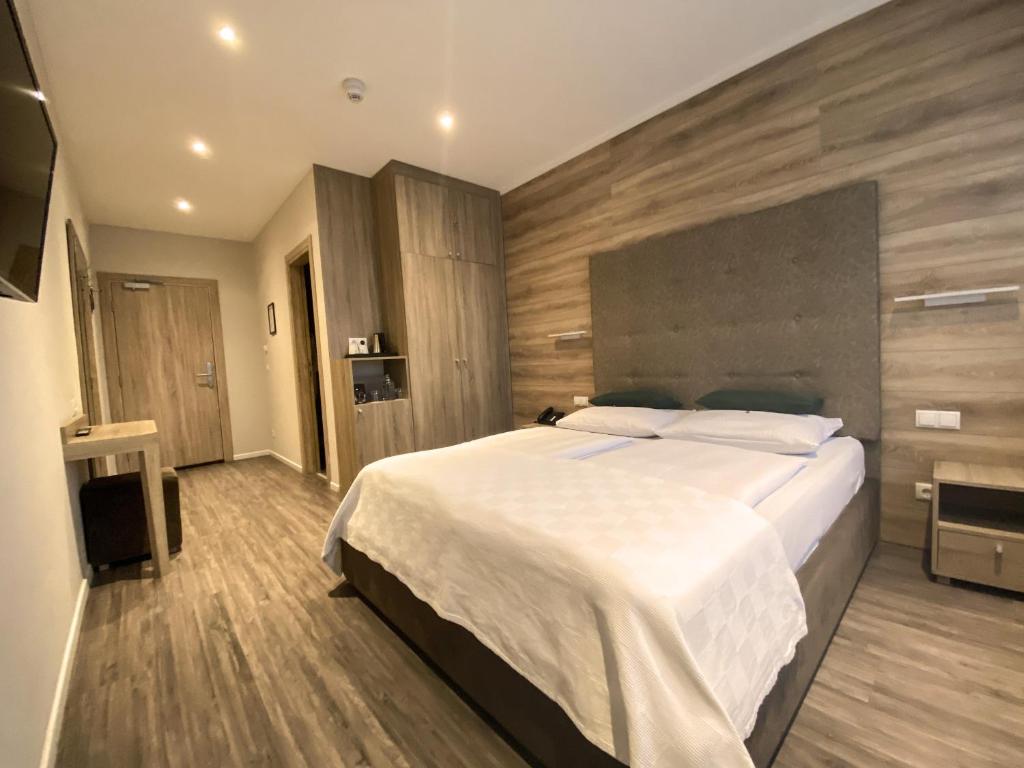 a bedroom with a bed and a dresser at Stadthotel Hamburg in Hamburg