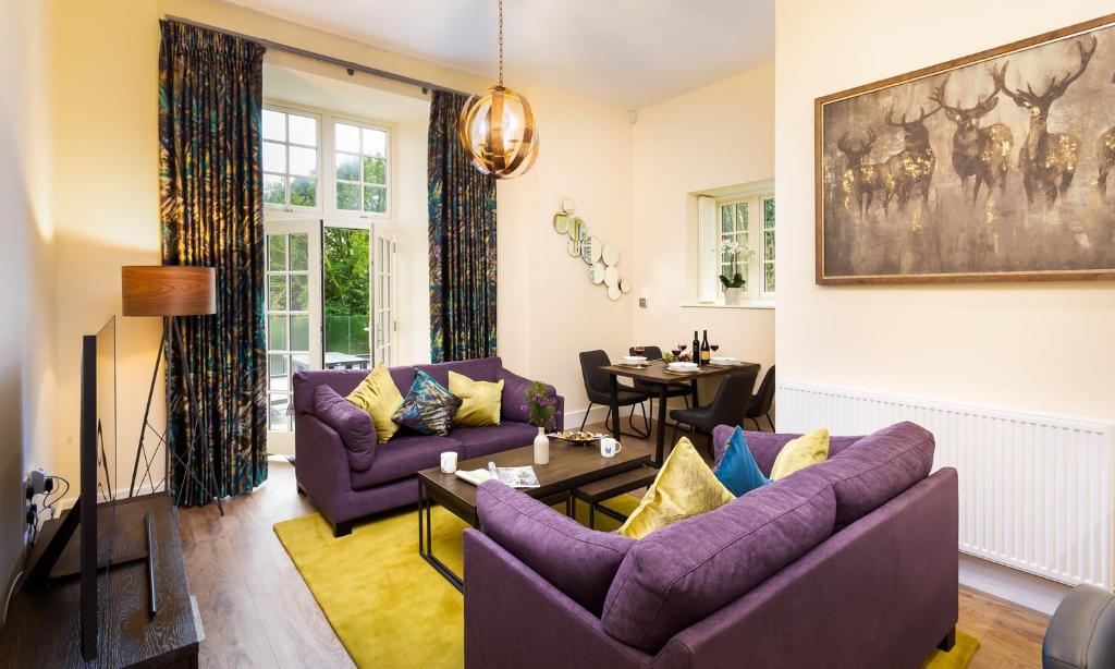 a living room with purple couches and a table at Larna Place in Ambleside