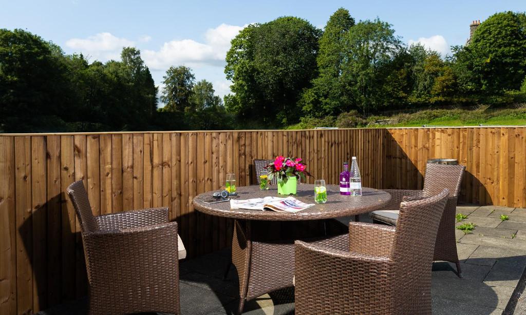 a table with chairs and flowers on a patio at Woodside West in Bowness-on-Windermere