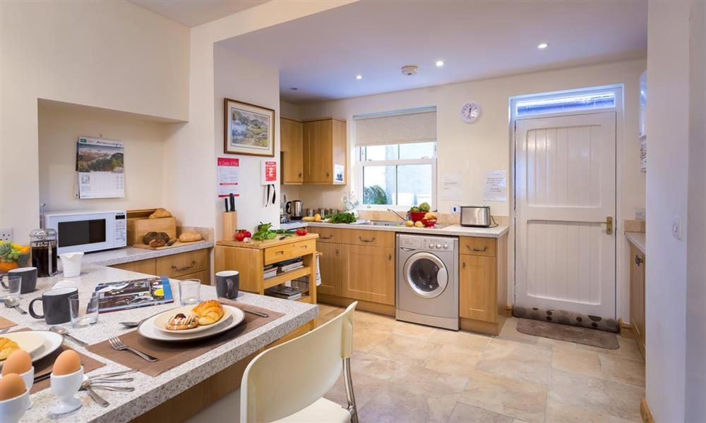 une cuisine avec un évier et une machine à laver dans l'établissement Mulberry Cottage, à Kendal
