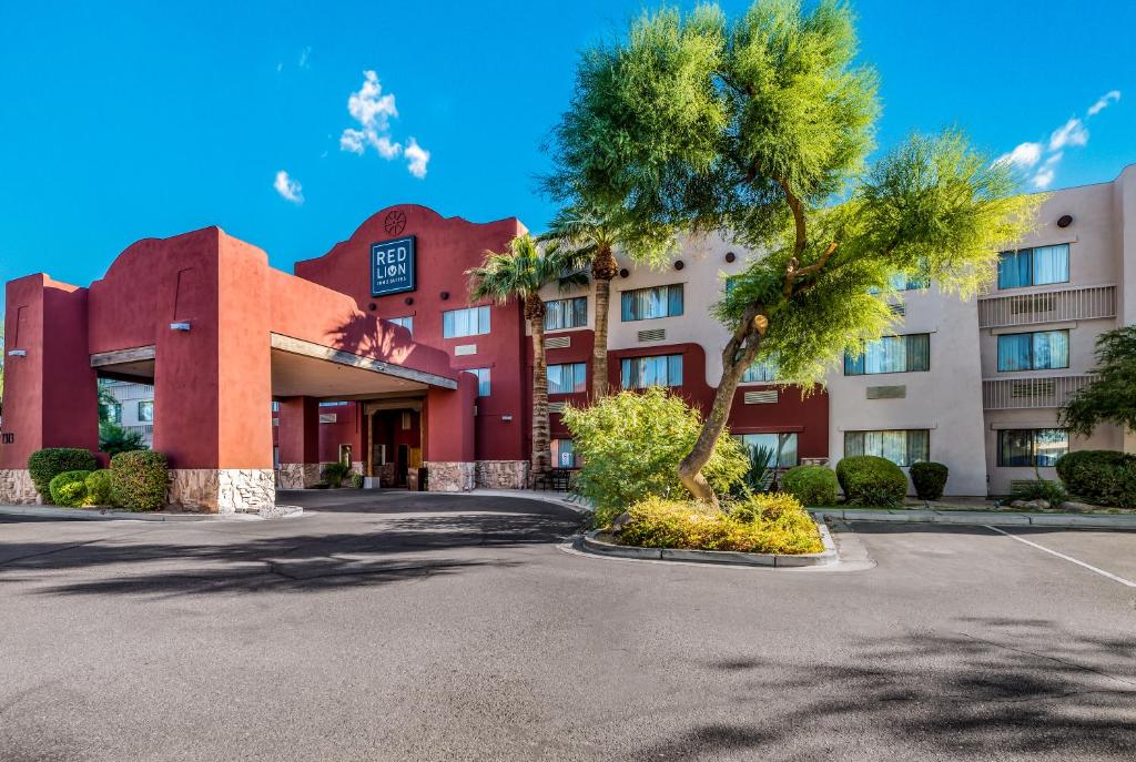 Red Lion Inn & Suites Goodyear في غوديير: مبنى امامه نخله