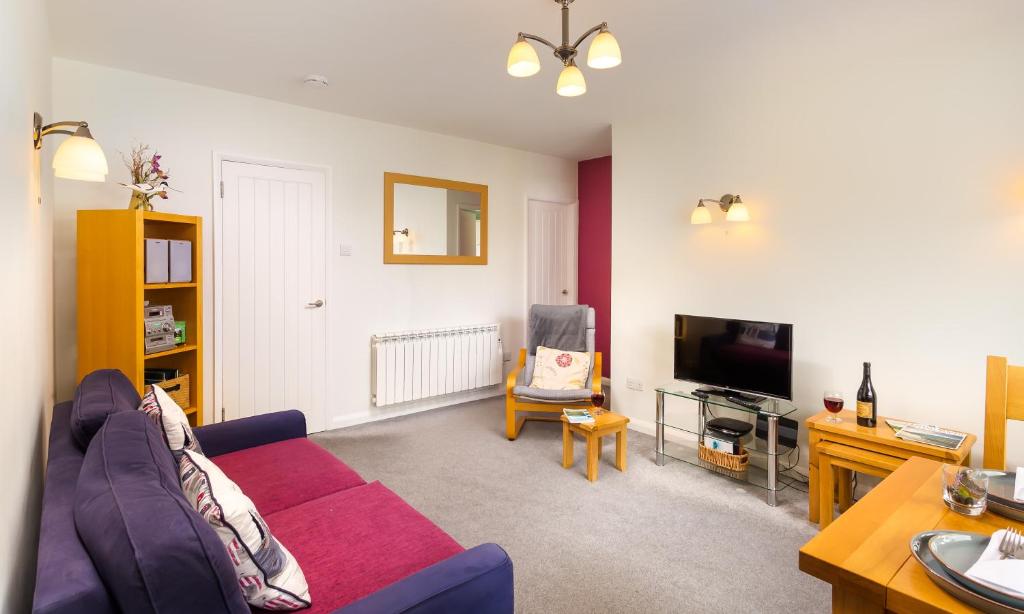 uma sala de estar com um sofá e uma televisão em Bow Peak em Bowness-on-Windermere