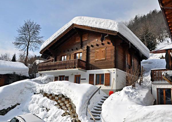 una casa de madera con nieve en el suelo en Stachelbeere OG en Fiesch