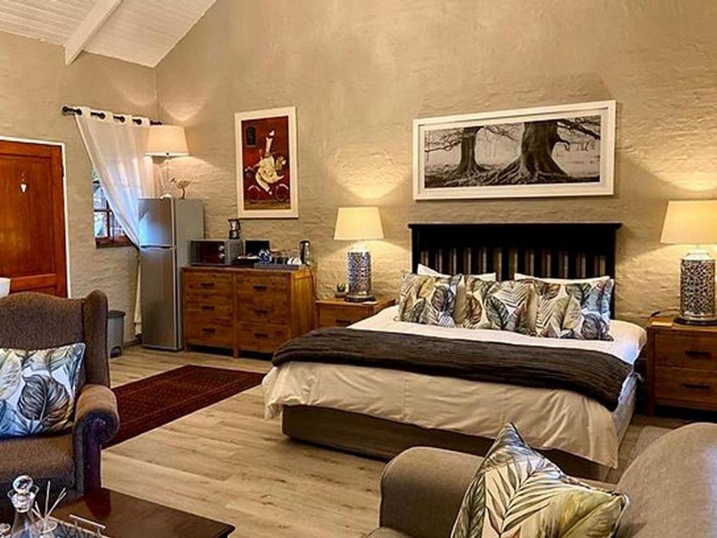 1 dormitorio con 1 cama grande y sala de estar en Lakeside Chalets Critchley Hackle Lodge, en Dullstroom