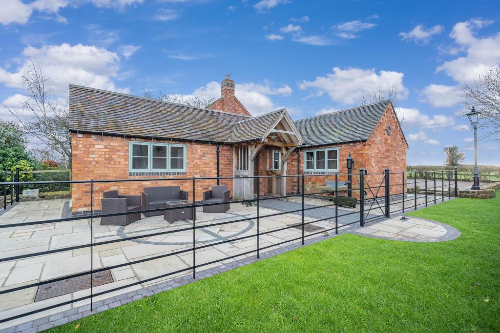 a brick house with a patio and grass at The Shed in Coventry