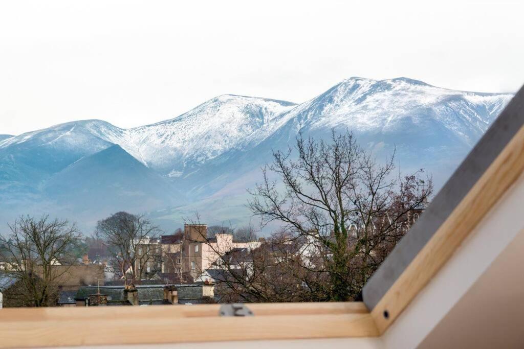 a view of snow covered mountains from a window at Lake Road Apartment Keswick in Keswick