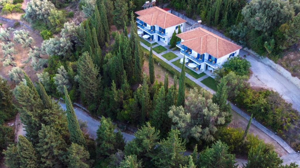 une vue sur une grande maison avec beaucoup d'arbres dans l'établissement Nymphs Rooms & Apartments, à Nikiana