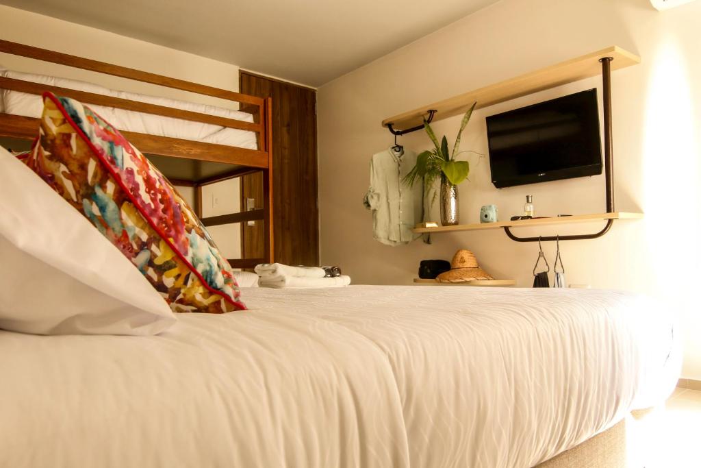 a bedroom with a bed with a tv on the wall at Hotel Tunebo Inn in Ríohacha