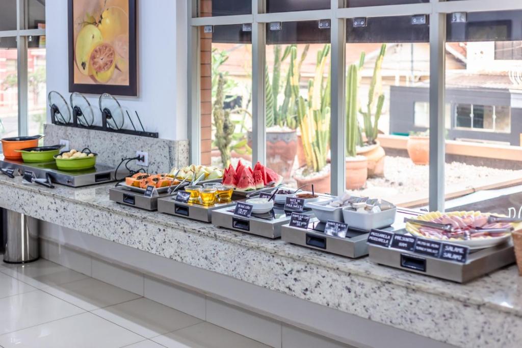 un buffet avec de nombreux types de nourriture différents dans l'établissement Hotel Pousada Ourinhos, à Ourinhos