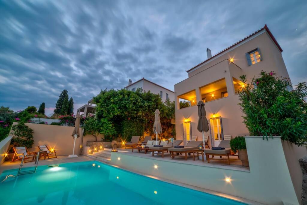a villa with a swimming pool at night at View-topia Amazing View, Private Pool, Close to the center. in Spetses