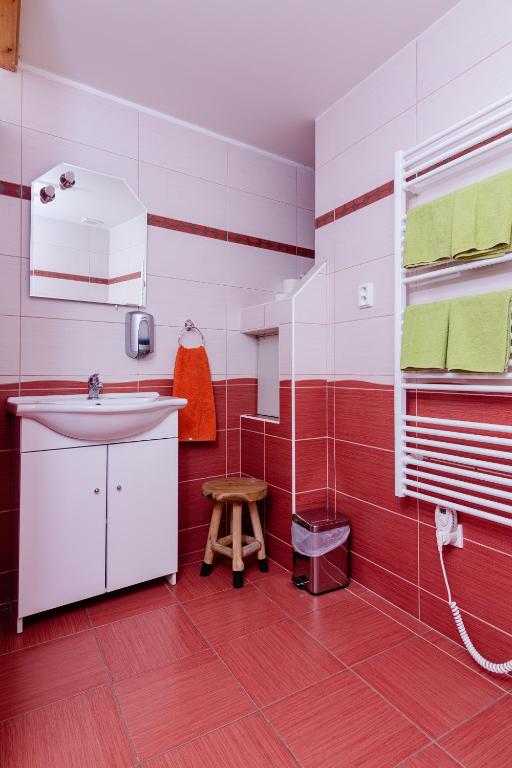 czerwono-biała łazienka z umywalką i oknem w obiekcie APARTMÁN CABERNET w mieście Velké Pavlovice