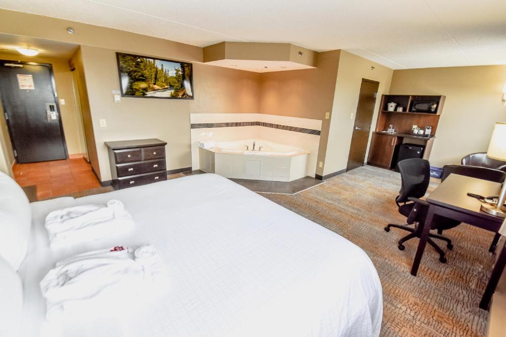 a hotel room with a large bed and a desk at Canad Inns Destination Centre Polo Park in Winnipeg