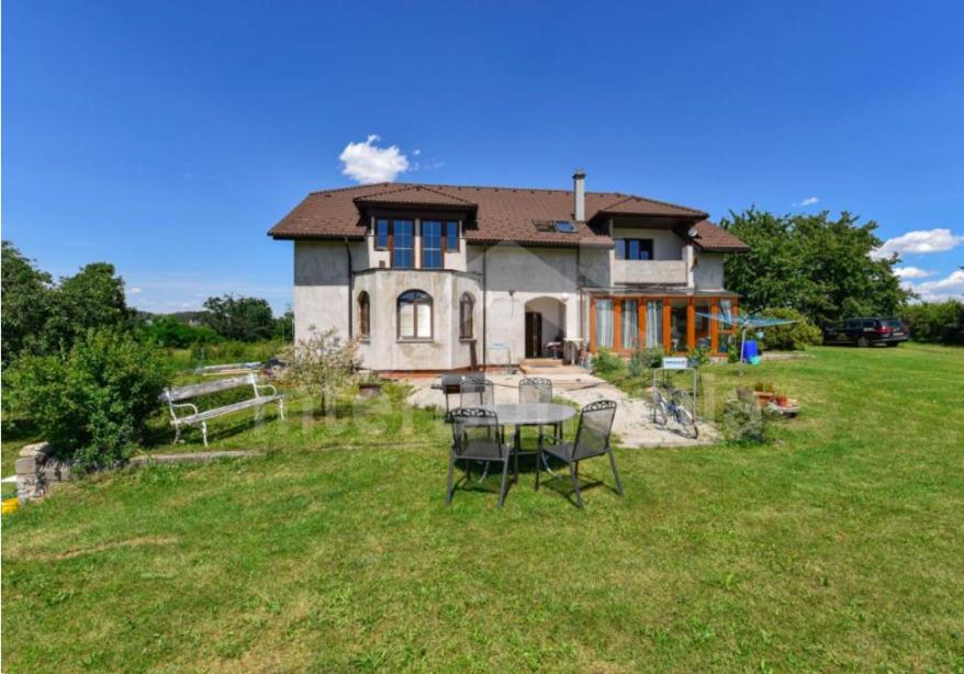 a house with a table and chairs in the yard at penzion Za lávkami in Dačice