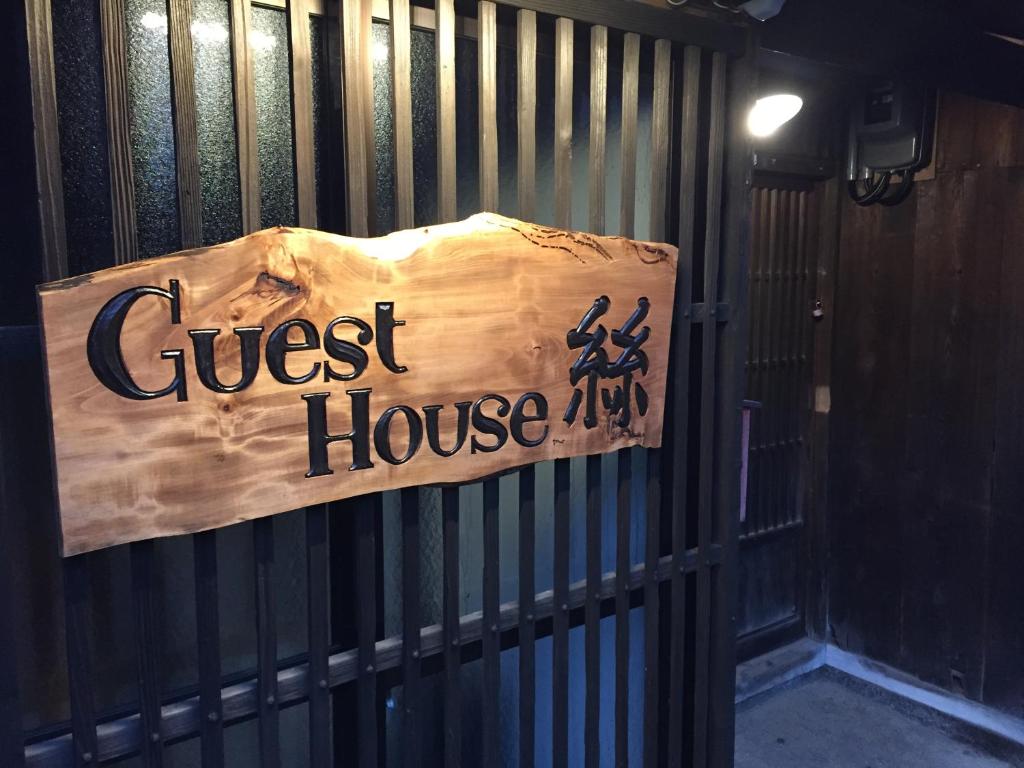 um sinal de casa de hóspedes pendurado numa cerca em guesthouse絲 -ito-ゲストハウスイト em Fukumitsu