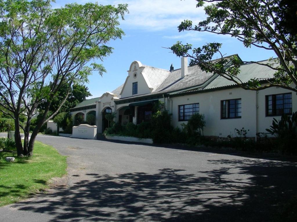 a large white house with trees in front of it at Somerset Guest Lodge - Western Cape in Somerset West