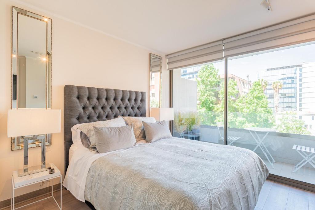 een slaapkamer met een groot bed met een groot raam bij Luxury Retreat w/ 2BR, Wifi, Pool, Gym in Santiago