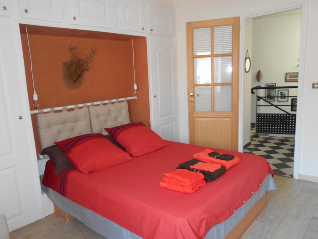 - une chambre avec un lit rouge et des oreillers rouges dans l'établissement Maison cocooning, à Roubia