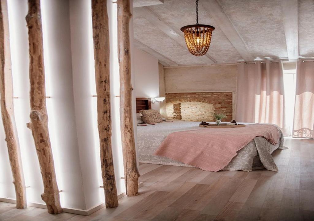 Casa Rural El Medievo- SOLO ADULTOS في تروخيلو: غرفة نوم فيها سرير مع طاولة