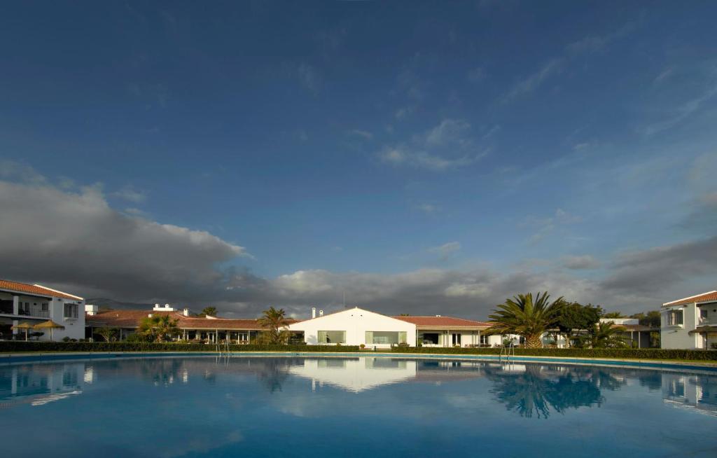 une grande piscine avec des maisons en arrière-plan dans l'établissement Parador de Málaga Golf, à Malaga