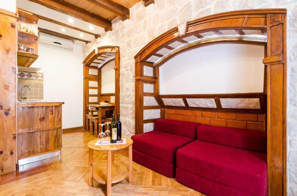 a red couch in a room with a brick wall at Apartment Soul of the Town in Dubrovnik