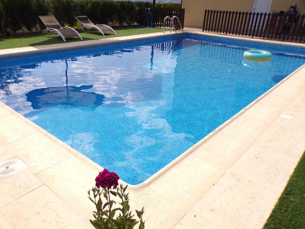 uma piscina com água azul e algumas cadeiras em Casa do Passarinho em Resende