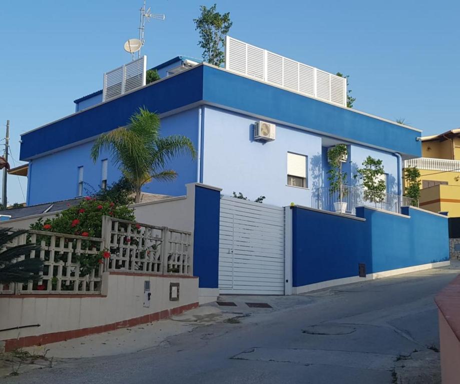 une maison bleue et blanche avec une clôture dans l'établissement Scala dei Turchi Beach house, à Realmonte