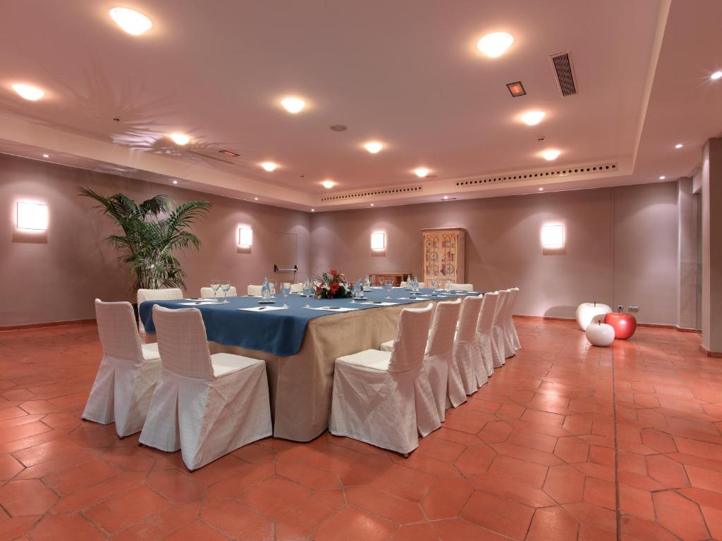 a large banquet room with a long table with white chairs at Parador de Málaga Golf in Málaga