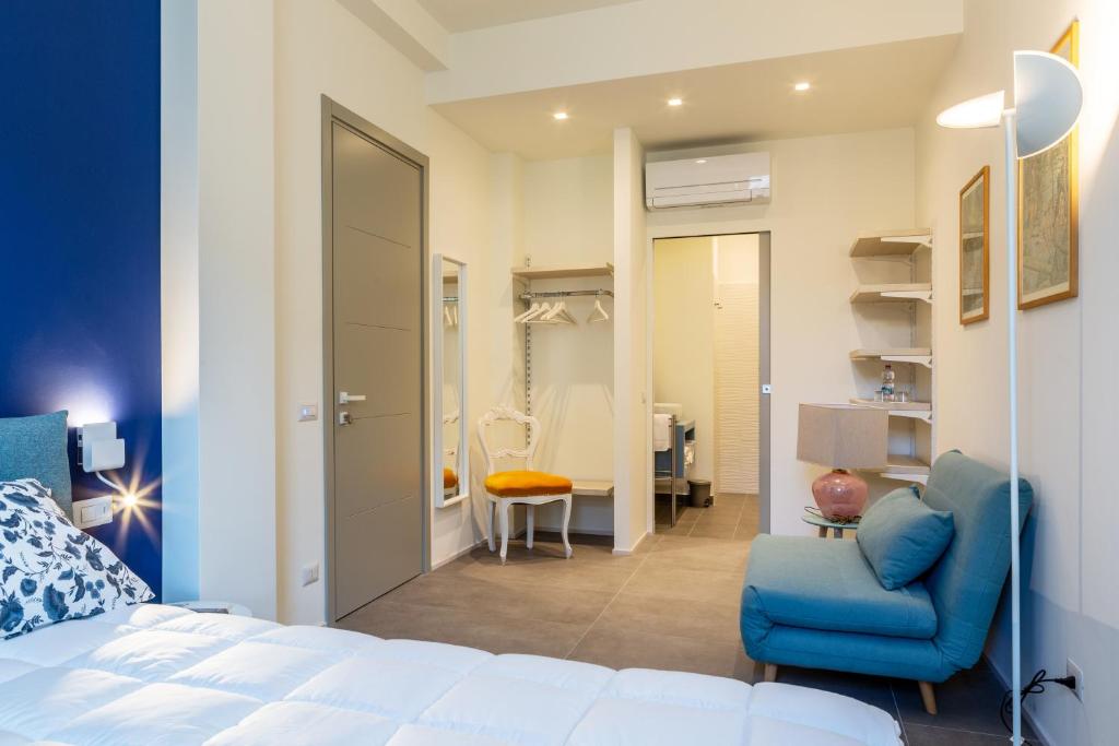 ein Schlafzimmer mit einem Bett und einem Stuhl sowie ein Badezimmer in der Unterkunft B&B PREVISTO SOLE in Civitanova Marche