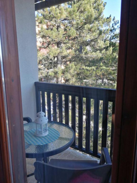 a table on a balcony with a view of a tree at Apartmani Sredojevic in Kaludjerske Bare