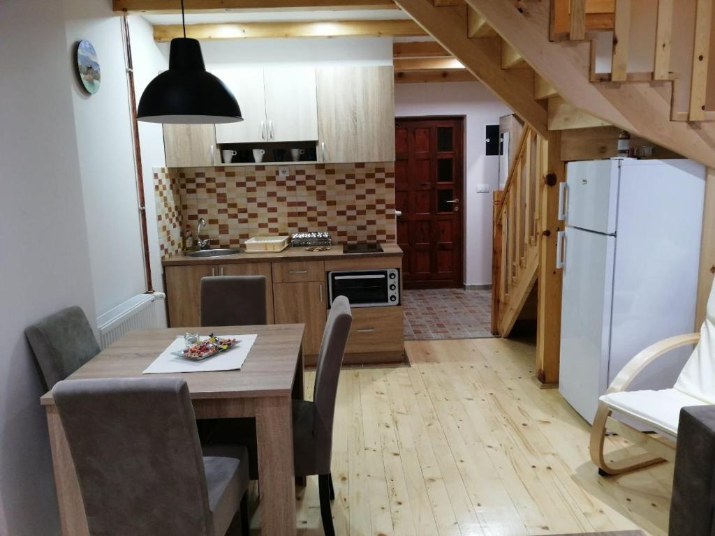 a kitchen with a wooden table and a white refrigerator at Apartmani Sredojevic in Kaludjerske Bare