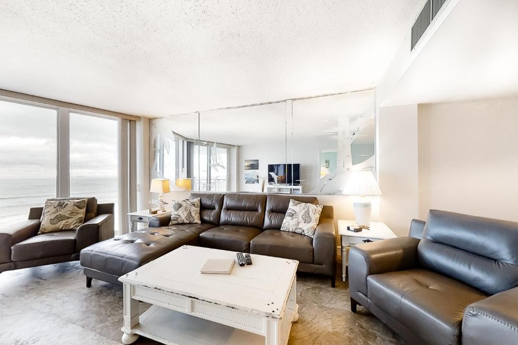 a living room with a couch and a table at Beach Escape Condos in Daytona Beach Shores