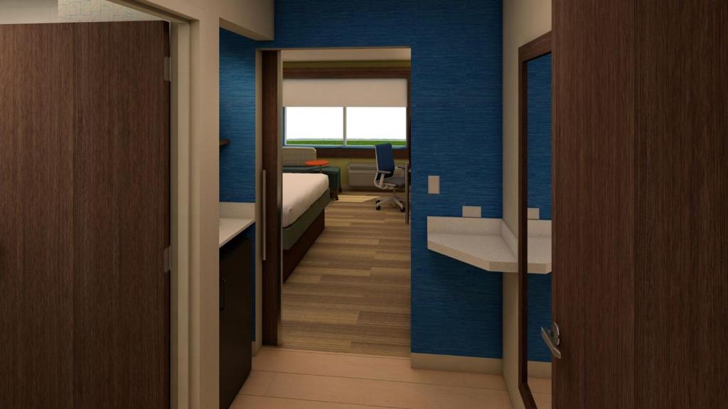 Pokój z niebieskimi ścianami, łóżkiem i biurkiem w obiekcie Holiday Inn Express & Suites Onalaska - La Crosse Area, an IHG Hotel w mieście Onalaska