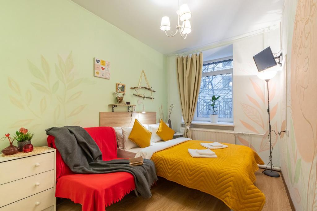 a bedroom with a bed with a red and yellow blanket at Boho Botanica Hotel on Nevskiy in Saint Petersburg