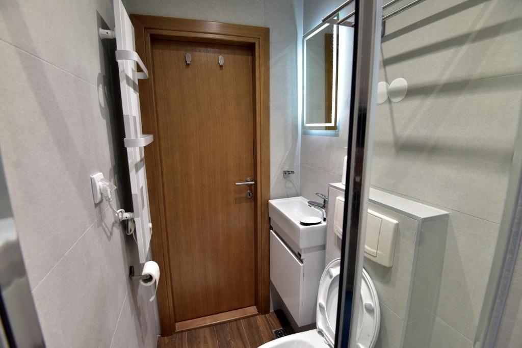 a small bathroom with a toilet and a wooden door at Kopaonik konak Koznik in Kopaonik