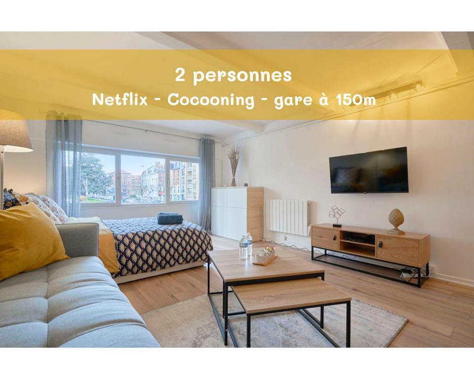 uma sala de estar com um sofá e uma mesa em LocationsTourcoing - Le Loir em Tourcoing