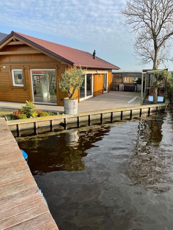 een huis met een dok naast een waterlichaam bij Vakantie huis aan het water in Rijpwetering