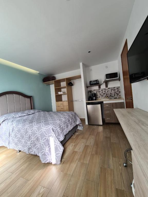 a bedroom with a bed and a kitchen at Acogedor loft privado en Coyoacán in Mexico City