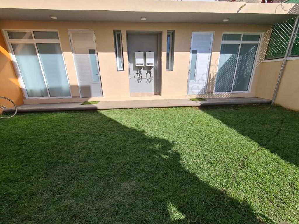 a house with a lawn in front of it at Acogedor loft privado in Mexico City