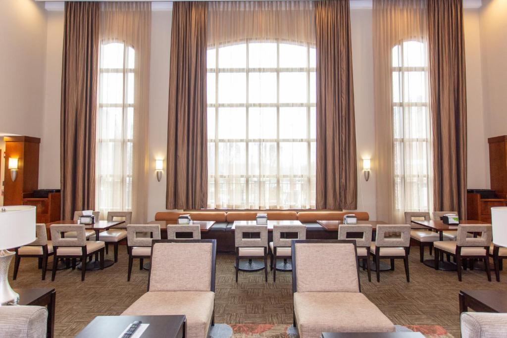 a waiting room with tables and chairs and windows at Staybridge Suites Bowling Green, an IHG Hotel in Bowling Green