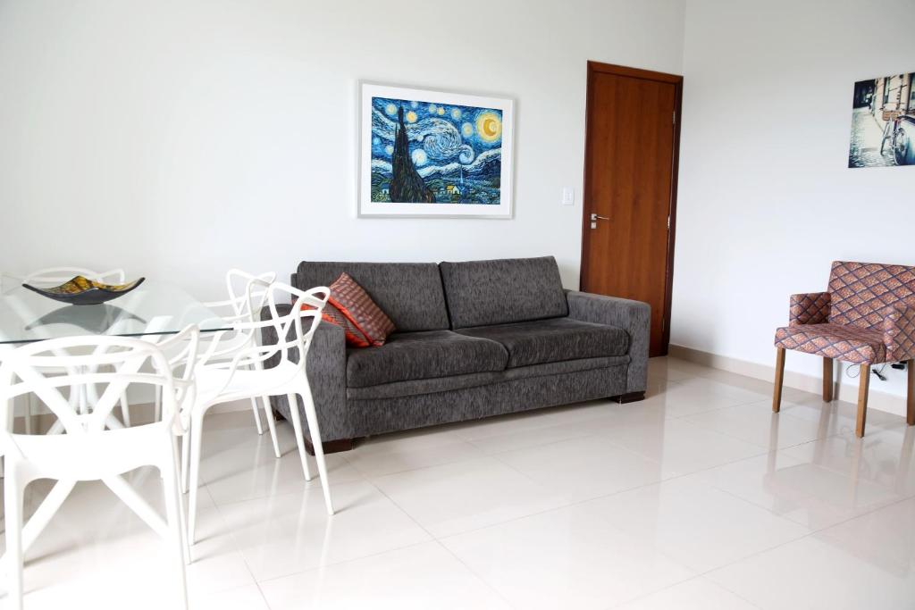a living room with a couch and a table and chairs at Apartamento Vista da Serra in Diamantina