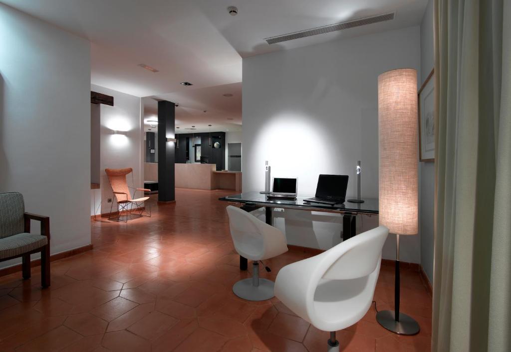 a living room with a desk with a laptop and chairs at Parador de Málaga Golf in Málaga