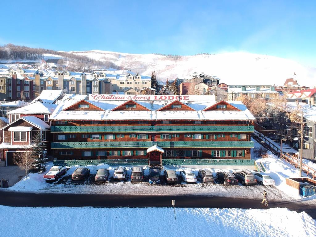 a building with cars parked in front of it in the snow at Chateau Apres Lodge in Park City