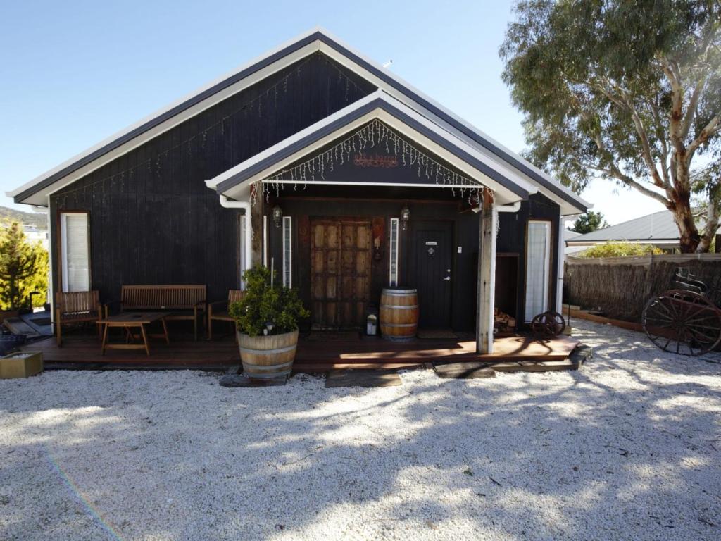 a black building with a porch and a table at Oak and Barrell 7 Twynam Street in Jindabyne