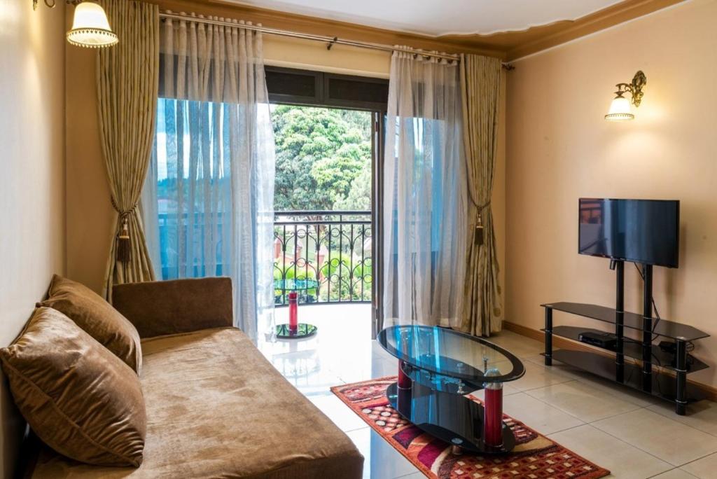 ein Wohnzimmer mit einem Sofa und einem großen Fenster in der Unterkunft Luxury 2 bedrooms apartment in Kampala in Kampala