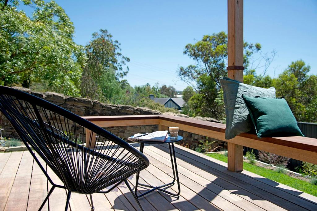 a chair sitting on a deck with a bench at 52Views Castlemaine in Castlemaine