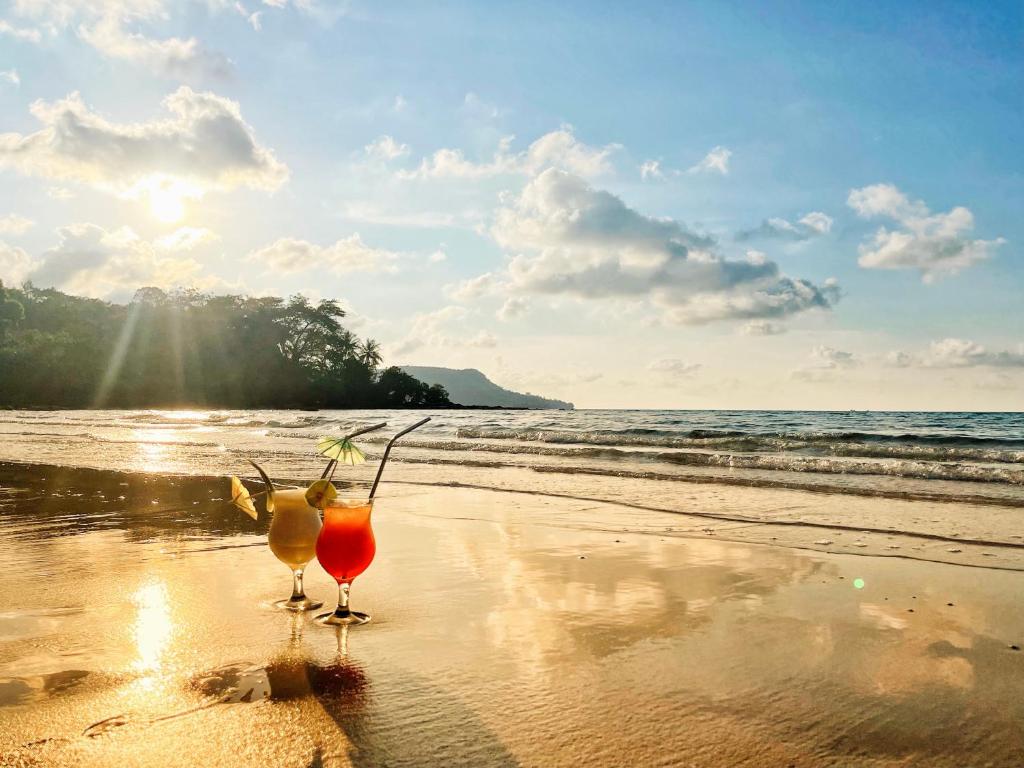 a couple of cocktails sitting on a beach at Lonely Beach in Koh Rong Island