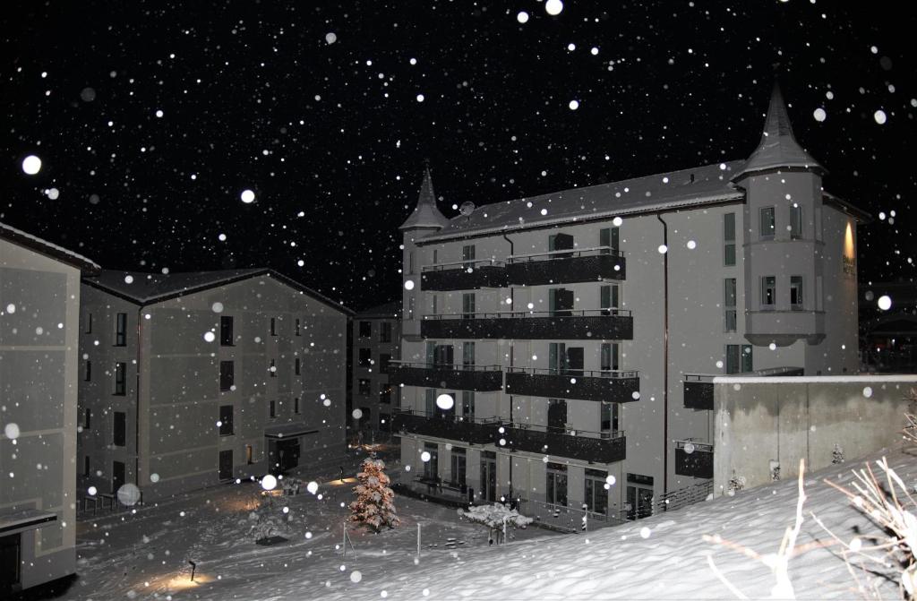 a snow covered city at night with buildings at Emma's B&B - Self Check-in Hotel in Lungern