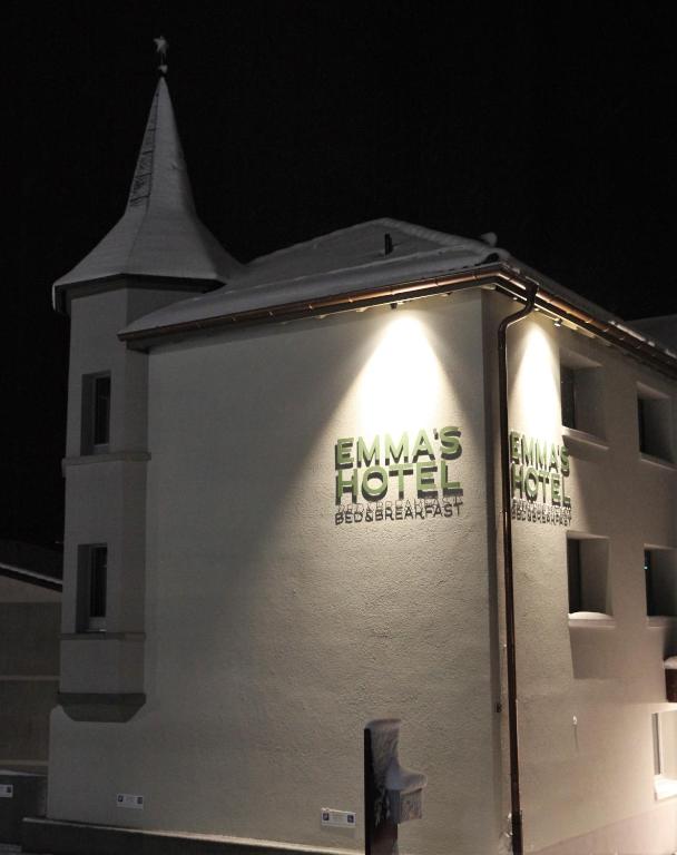 a white building with lights on the side of it at Emma's B&B - Self Check-in Hotel in Lungern