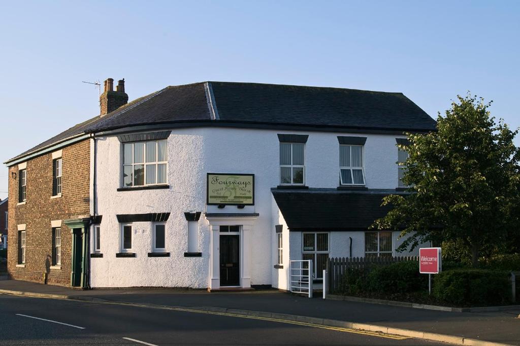 un edificio blanco en la esquina de una calle en Fourways Guest House, en Thirsk